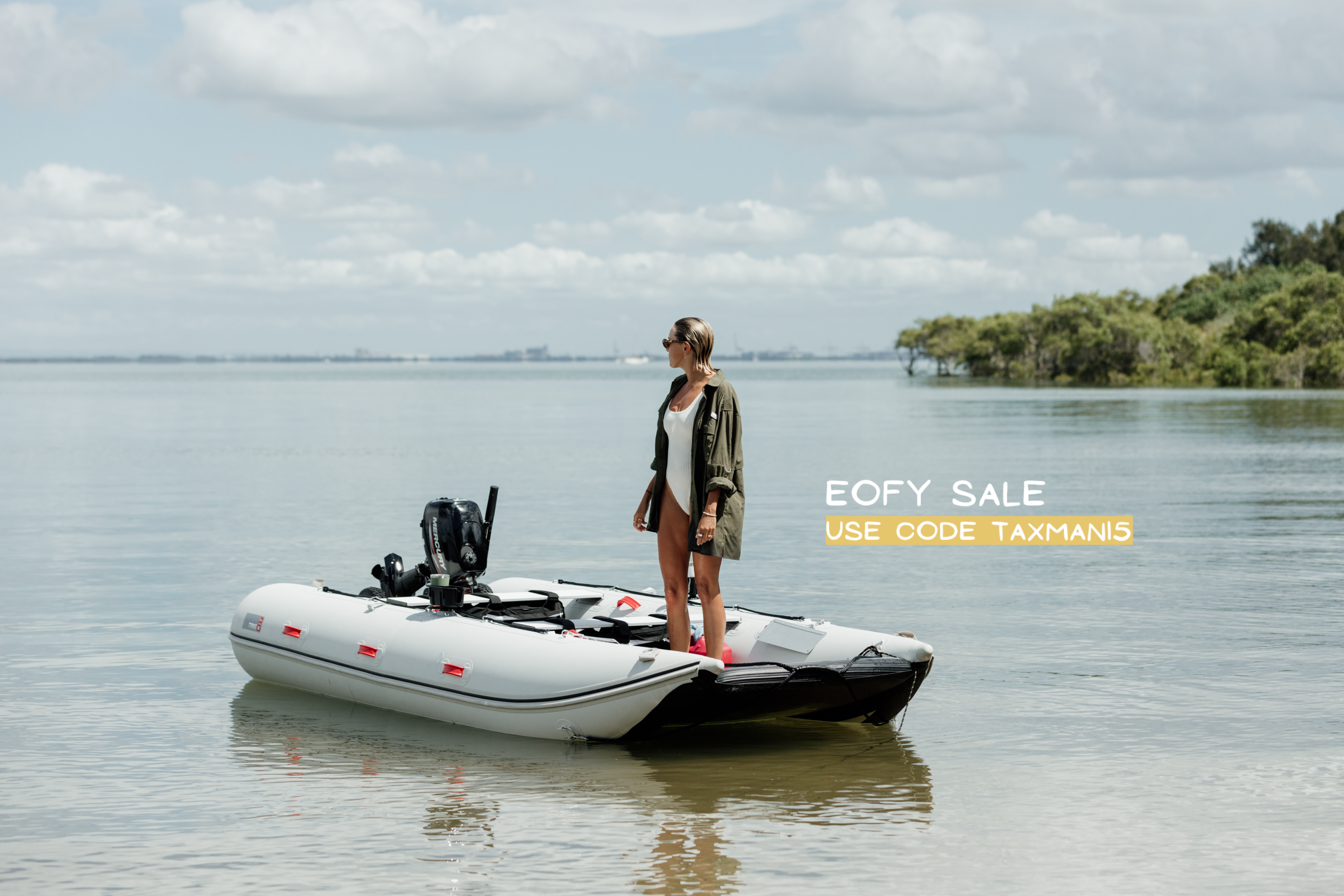 Woman standing on a small inflatable boat on a calm lake with a sale advertisement overlay 15% off EOFY sale.