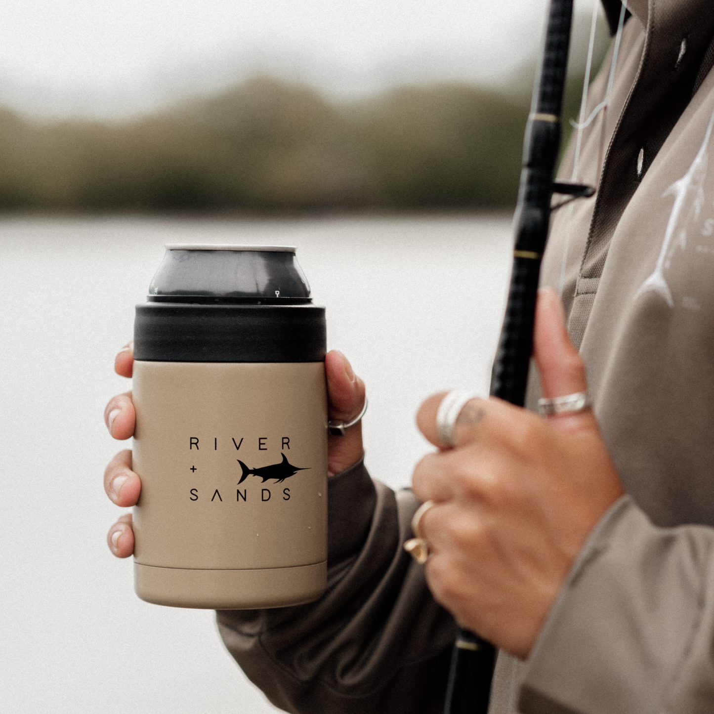 A fisherman holding the tan insulated can cooler.