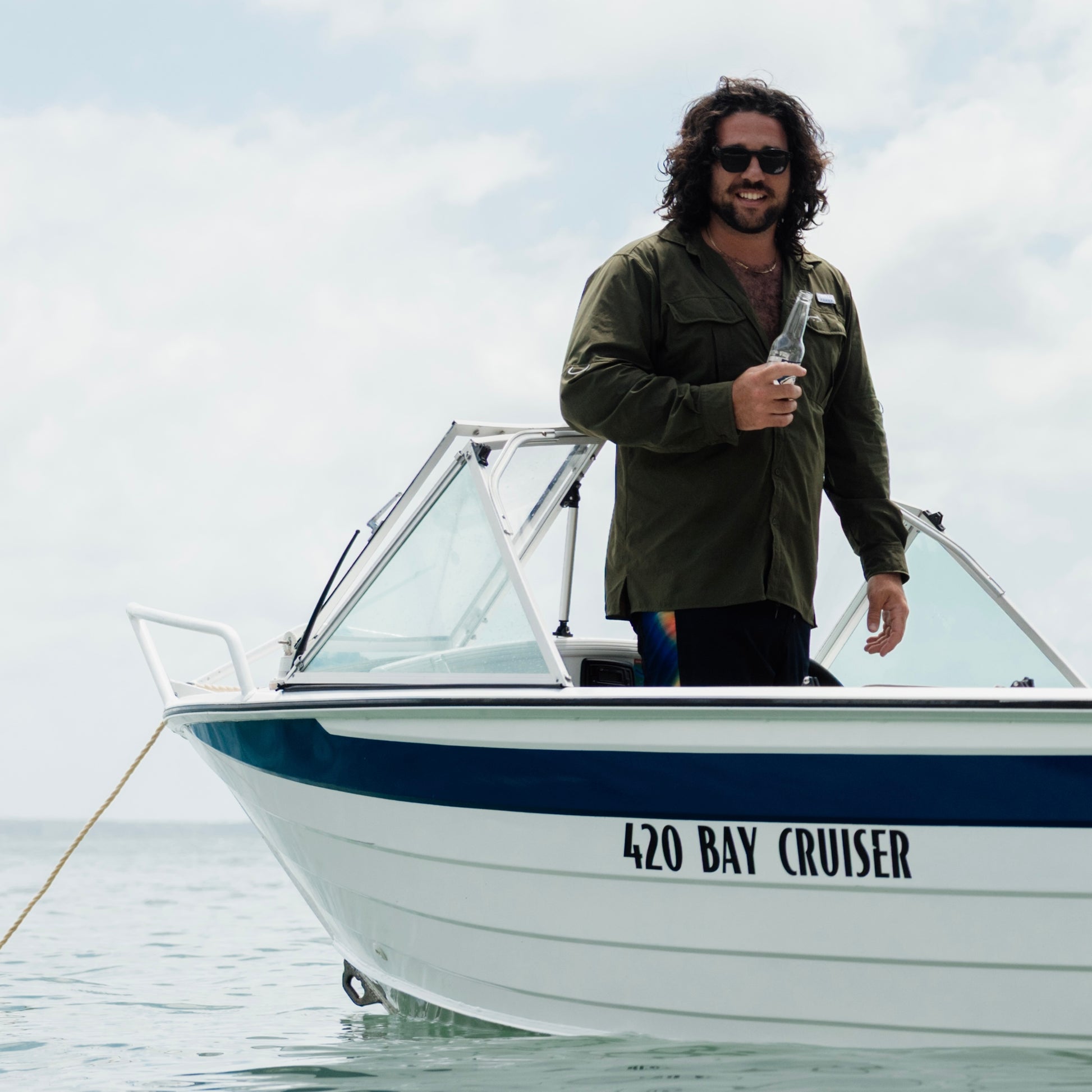 A man on a boat wearing the Khaki River Adventure Shirt outdoors – lightweight, quick-dry performance gear designed in Brisbane.