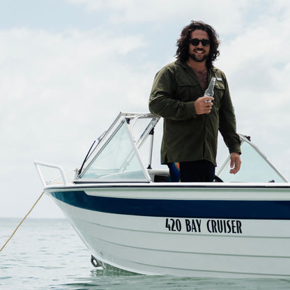 A man on a boat wearing the Khaki River Adventure Shirt outdoors – lightweight, quick-dry performance gear designed in Brisbane.